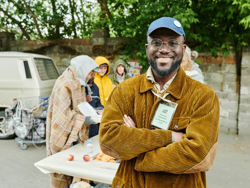 Volunteer helping homeless people outdoors